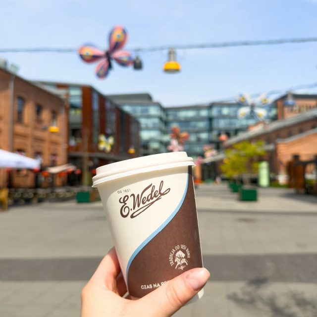 Złap kawkę na wynos w @wedelkoneser, wyjdź na Plac Konesera i po prostu… zwolnij.  Trochę zieleni, słońce między budynkami, industrialna architektura, rzeźby i ten spokojny, miejski klimat. ☀️  Kto wpada na taki reset? ☕  #koneser #warszawa #wedelkoneser #wiosennyspacer #kawa